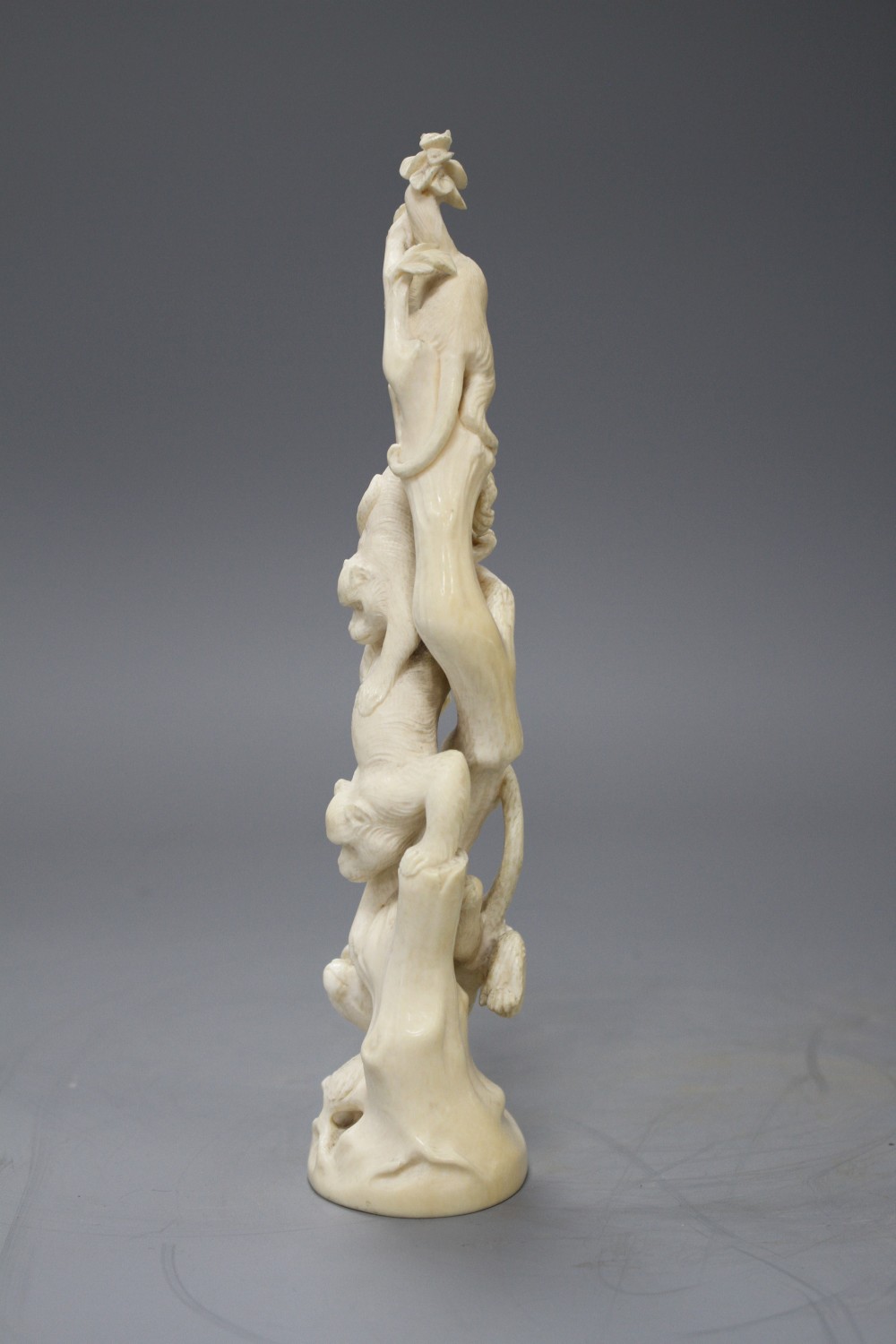 A Japanese Meiji period Tokyo School okimono carved with monkeys climbing a tree, unsigned, height 21.5cm